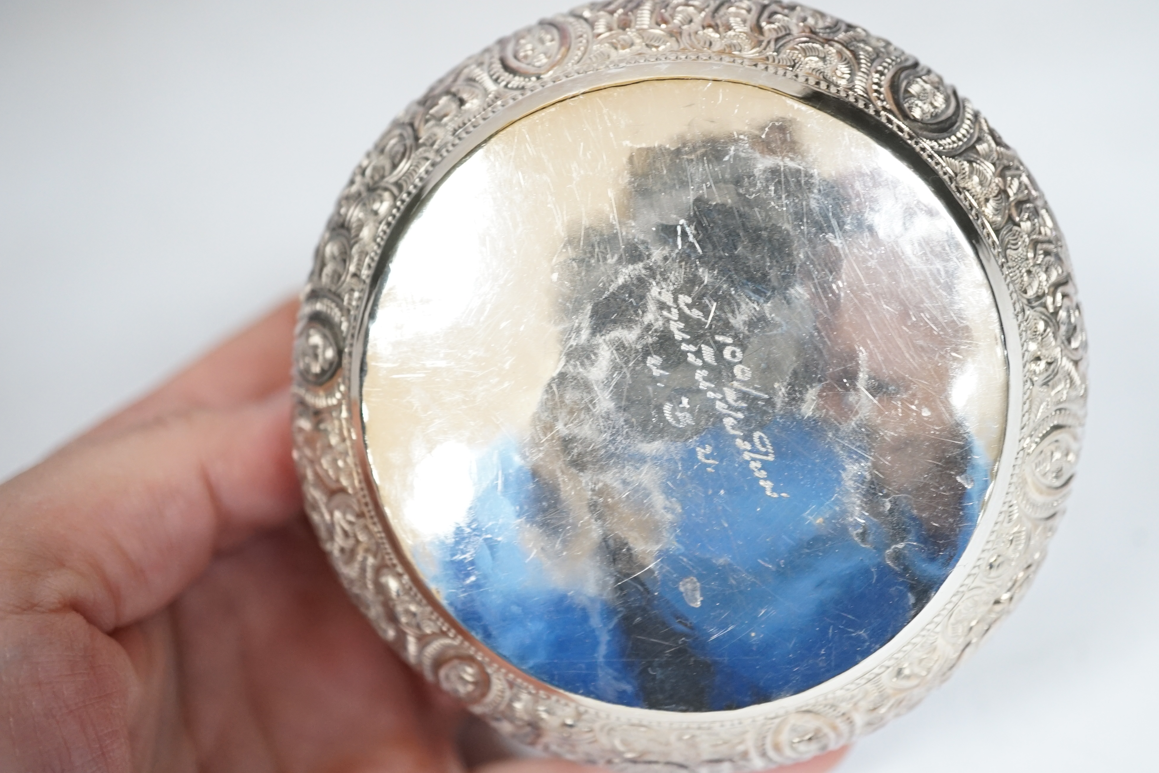 A pair of Thai circular white metal bowls, and a pair of small bowls, all decorated with animals and foliate scrolls, inscribed on bases, diameter 12cm and 8.5cm